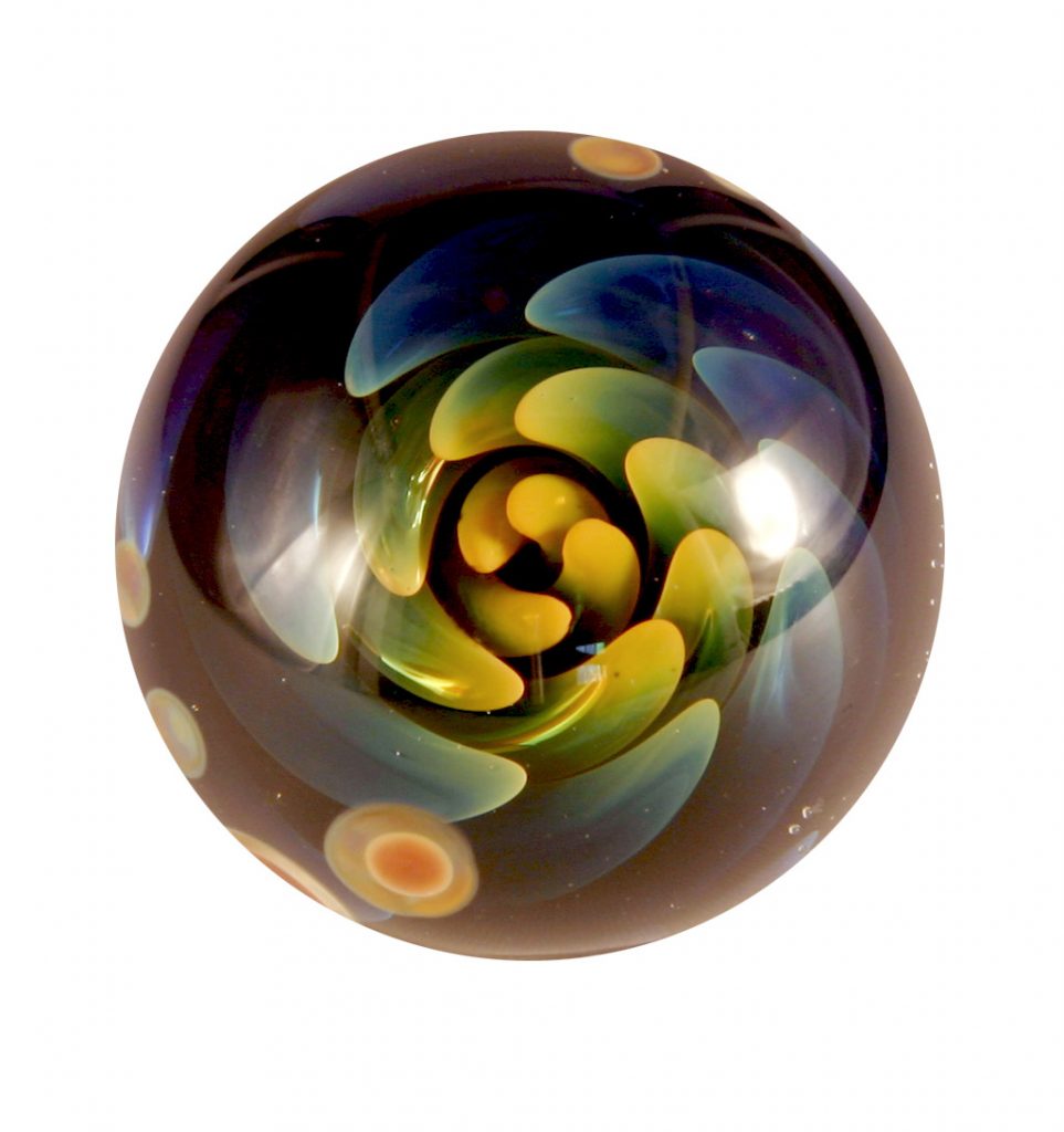 Glass marble with yellow, green, and blue swirls.